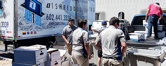 Employees assisting in the drop off shredding process